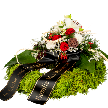 Trauerkranz mit roten Rosen und weißen Lilien